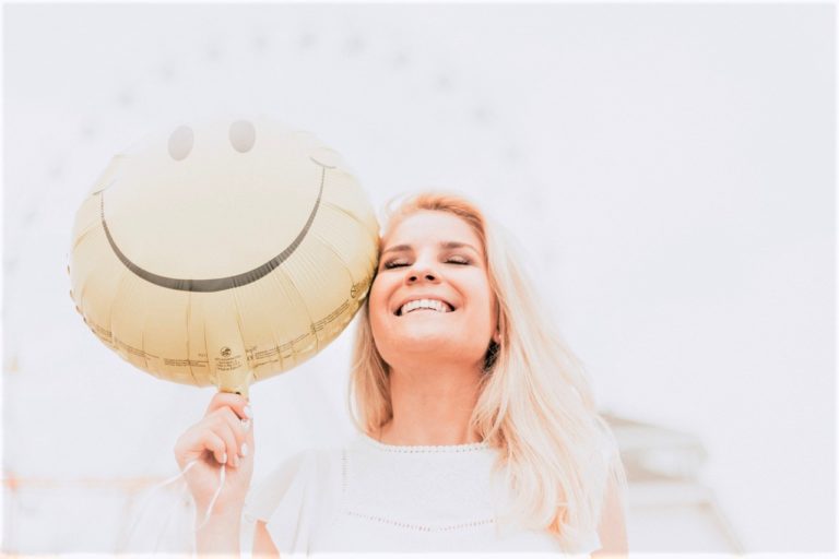 woman smiling and holding a balloon