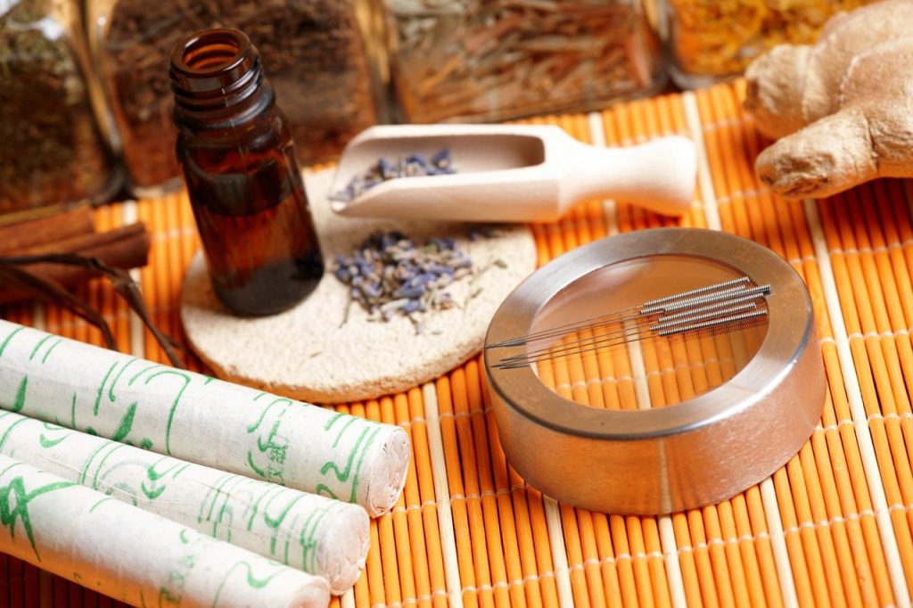 Acupuncture needles and essential oils on a table
