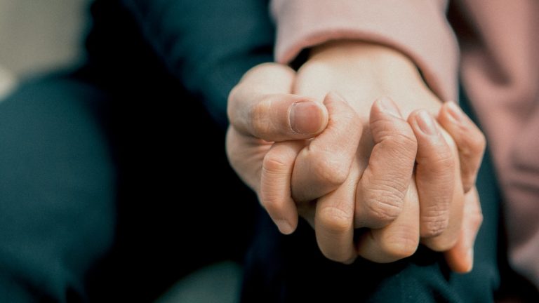 close up of two people holding hands